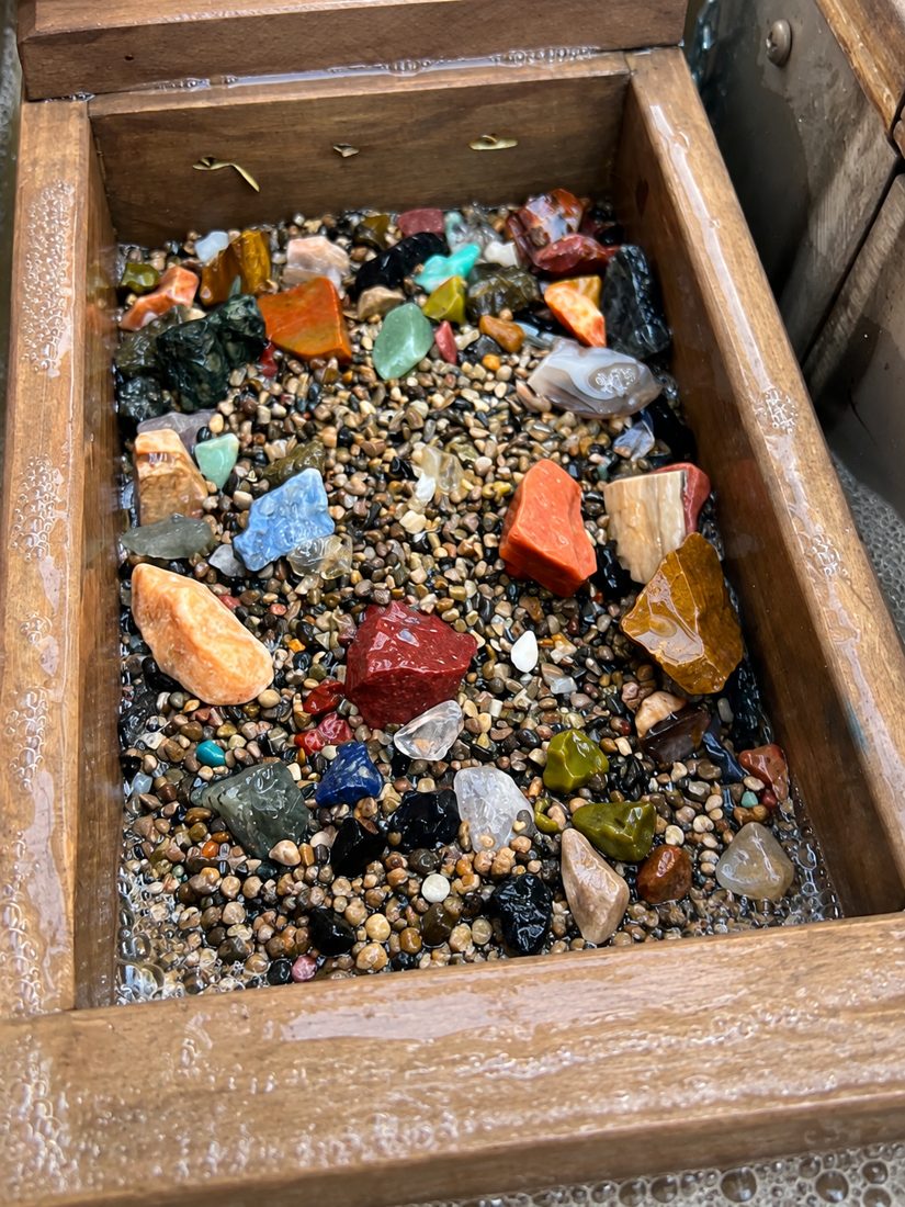A screen full of washed rough gems in red, orange, blue, green and clear quartz